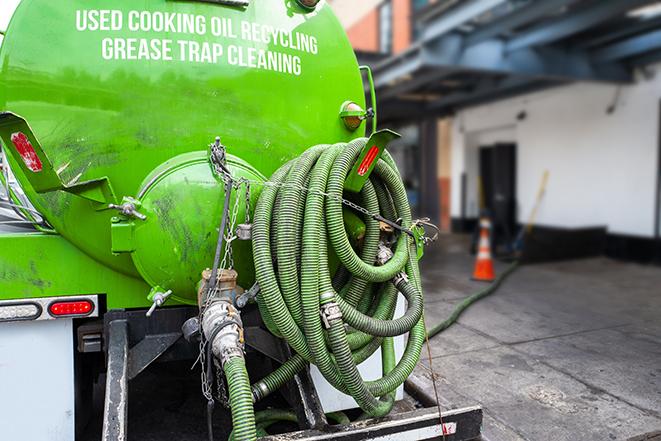 technicians pumping out a commercial grease trap in Acton